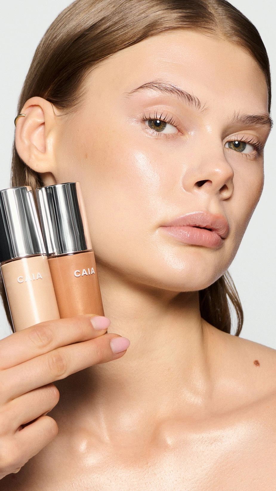 model holding Wake me up complexion enhancer in two shades